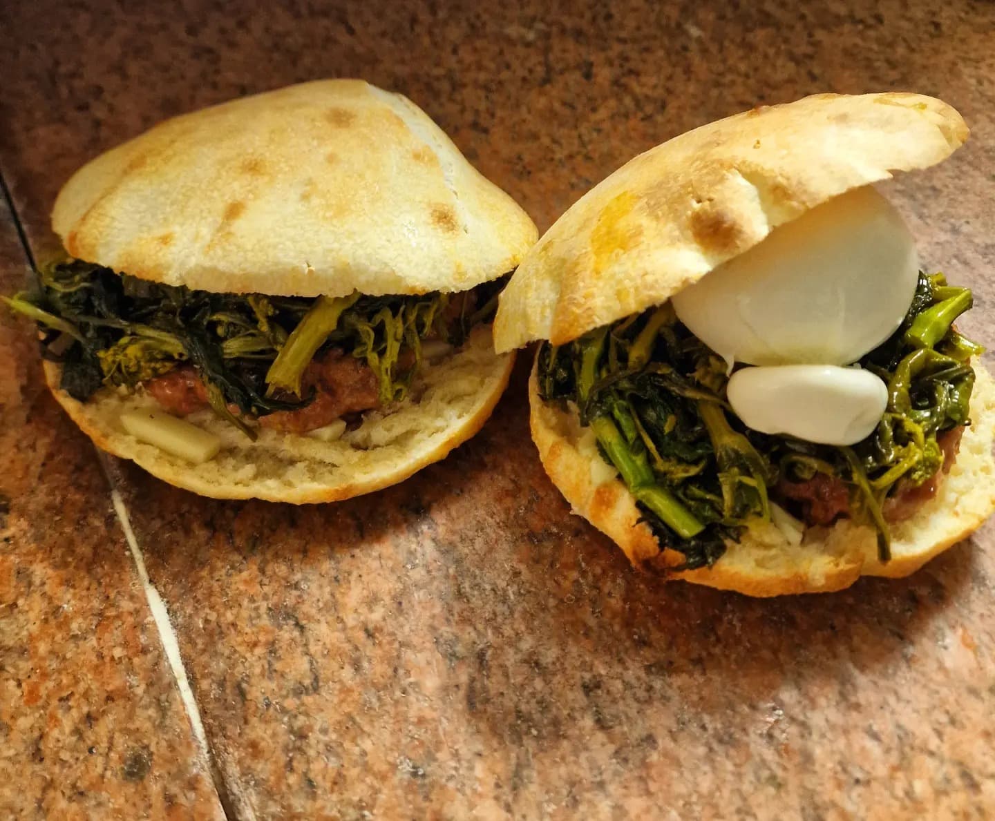 Un catuozzo tagliato a metà, farcito con salsiccia, friarielli e mozzarella